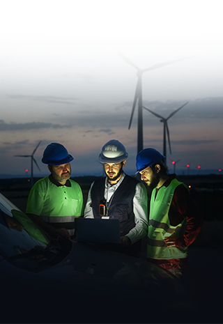 Team of wind turbines engineers standing by the service car in the evening on wind farm site and checking specifications.